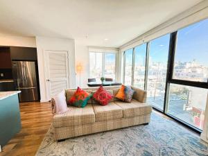 a living room with a couch and large windows at Boutique KTown Stays With Breathtaking Rooftop Views in Los Angeles