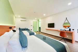 Xóm TramAmigo Sol Phan Thiet的一间有两张床和一台电视的酒店房间