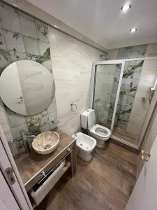 a bathroom with a toilet and a sink and a mirror at Chiara's Apartament panoramico in Santa Teresita +29 photos
