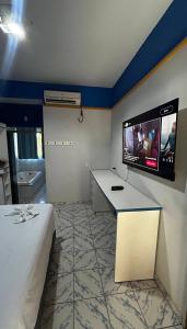 a room with a tv on the wall and a bed at Hotel MarVinhal in Santa Maria