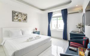 a white bedroom with a bed and a chair at La Casona Retreat in Ho Chi Minh City