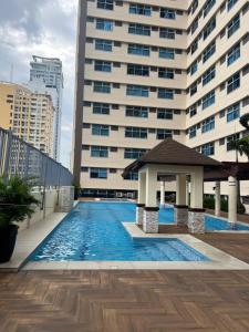 einen Pool mit einem Pavillon vor einem Gebäude in der Unterkunft Robinson's Place Residences, in Manila