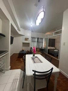 eine Küche und ein Wohnzimmer mit einem weißen Tisch und Stühlen in der Unterkunft Robinson's Place Residences, in Manila
