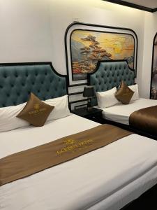 two beds in a hotel room with a sign on them at Golden Hotel in Hanoi