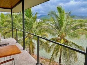 卡德韦尔Hichinbrook Lodge, waterfront的阳台配有桌子和棕榈树