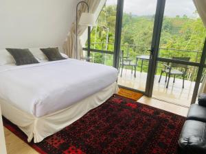 Un dormitorio con una cama y vista a un balcón. en Rain Drops Wellness Villa Sinharaja, en Mederipitiya