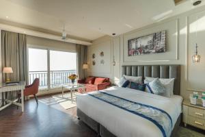 a bedroom with a large bed and a living room at Vaydantaa - Luxury Boutique Hotel Mussoorie in Mussoorie