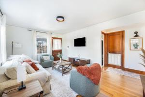 een woonkamer met een bank en een tv bij Sage & Stone Cottage in Lynchburg