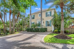 a house with palm trees in front of a driveway at Hemingway House - 117 in Siesta Key