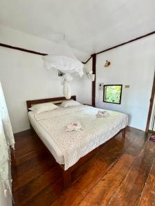 1 dormitorio con 1 cama con sábanas blancas y suelo de madera en Tavendang Guesthouse, en Don Det 8 fotos más