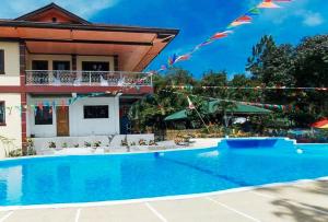 a swimming pool in front of a house with flags at Sunrise Garden Lake Resort in Lahit