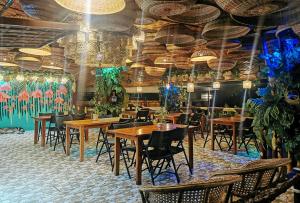 a restaurant with wooden tables and chairs and chandeliers at Sunrise Garden Lake Resort in Lahit