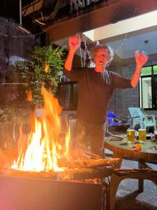 a man standing in front of a grill with fire at Hotel Diplomat in Pokhara