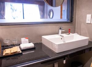 a bathroom with a white sink on a counter at Soaltee Westend Lakeside Pokhara in Pokhara +21 photos