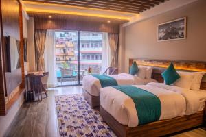two beds in a hotel room with a window at Soaltee Westend Lakeside Pokhara in Pokhara