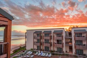 uma vista para um hotel com cadeiras e a praia em Le Battant Des Lames em Saint-Pierre