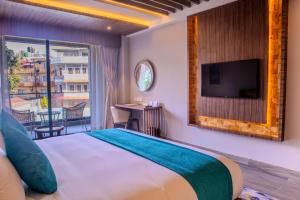 a hotel room with a bed and a television at Soaltee Westend Lakeside Pokhara in Pokhara