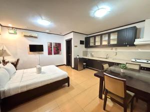 CabaguioD' Leonor Hotel的客房设有一张床、一张书桌和一间厨房