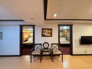 CabaguioD' Leonor Hotel的带两面镜子的房间和一间带两张床的房间