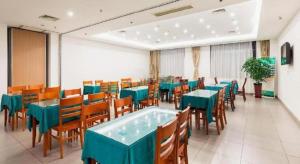 a dining room with blue tables and wooden chairs at GreenTree Inn Jiangsu Wuxi Meiyuan Kaiyuan Temple Subway Master Station Express Hotel in Wuxi