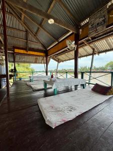 Un pabellón con tres colchones sobre un suelo de madera. en Tavendang Guesthouse, en Don Det