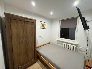 Un dormitorio pequeño con una cama y un armario de madera. en SAS Militaria dla 2 par 2 pokoje 4 osoby, en Borne Sulinowo