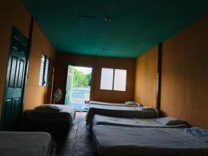 a room with four beds and a window at Hotel My Isla Bonita in Moyogalpa