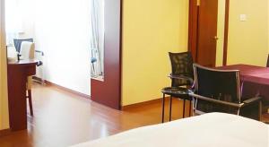 una habitación con dos sillas y una mesa y una cama en GreenTree Inn Shanghai Songjiang Xinqiao Jiuxin Road Express Hotel, en Chunshen