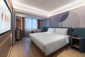 Una cama o camas en una habitación de Orange Hotel Shenzhen Futian Convention and Exhibition Center