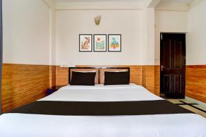 ein Schlafzimmer mit einem großen weißen Bett in einem Zimmer in der Unterkunft Hotel O Bharata Mata College Kakkanad in Kochi + 23 Fotos