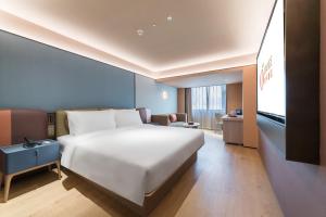 Una cama o camas en una habitación de Orange Hotel Shenzhen Futian Convention and Exhibition Center