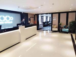 um homem em pé em frente a uma tela em um prédio em Xana Hotelle Jinan Daminghu North Gate em Jinan