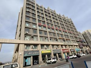 a large building with cars parked in front of it at Xana Lite Korla Xiangli Avenue Food Street in Korla