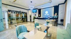 a lobby with a table and chairs in a building at Xana Lite Guiyang Huaguoyuan Shuangzi Towers in Guiyang