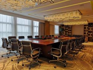 Una gran sala de conferencias con una mesa grande y sillas. en Lakehome Hotel Konggang, en NKG