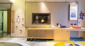 sala de estar con TV grande en la pared en Lakehome Hotel Konggang, en NKG