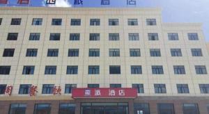 um grande edifício branco com escrita chinesa em PAI Hotel·Ulan Chaka Salt Lake em Caka