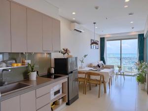 a kitchen and dining room with a table and a kitchen and a dining room at The Sóng 5 Star Apartment 5 Star Vung Tau - Căn Hộ Du Lịch 5 Sao Cạnh Biển in Vung Tau