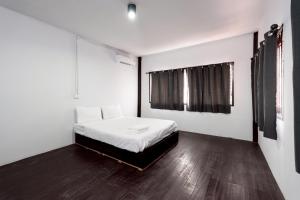 a bedroom with a bed with white sheets and a window at XX Mitr Khaosan Bangkok in Bangkok