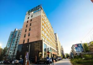 a tall building on a city street with cars parked at City Comfort Inn Xianning Tongshan Education Bureau in Tongshan
