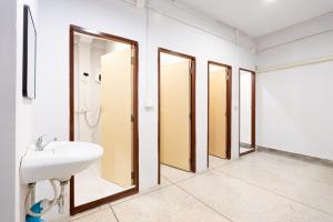 a bathroom with three mirrors and a sink at XX Mitr Khaosan Bangkok in Bangkok +45 photos