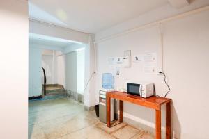 a room with a table with a microwave on a wall at XX Mitr Khaosan Bangkok in Bangkok