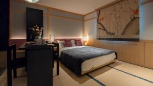 a bedroom with a bed and a desk with flowers at Aank Resort & Spa Busan Haeundae in Busan +291 photos