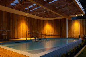an indoor swimming pool with a wooden wall at Tasman Holiday Parks - Papamoa Beach in Papamoa
