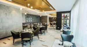 um restaurante com mesas e cadeiras em uma sala em Magnotel Tongxiang Shimao Center em Tongxiang