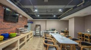 a dining room with a long table and chairs at James Joyce Coffetel Shijiazhuang the Mixc Jinyuan Tower Airport Bus in Shijiazhuang