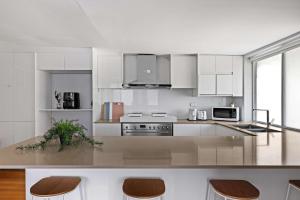 a kitchen with white cabinets and a counter with stools at Light & Simple Single Room - Peakhurst Area - Shared Bathroom in Peakhurst +14 photos