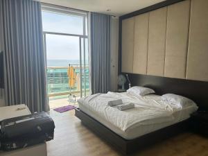a bedroom with a bed and a large window at Ocean Vista Resort Sealink Phan Thiet in Ấp Phú Tịnh (2) +11 photos