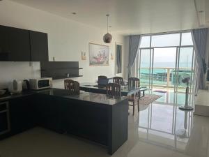 a kitchen with a table and chairs and a large window at Ocean Vista Resort Sealink Phan Thiet in Ấp Phú Tịnh (2)