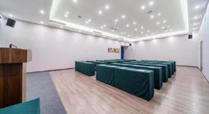 uma sala com mesas verdes e cadeiras em IU Hotel Chongqing Airport T3 Terminal em Chongqing